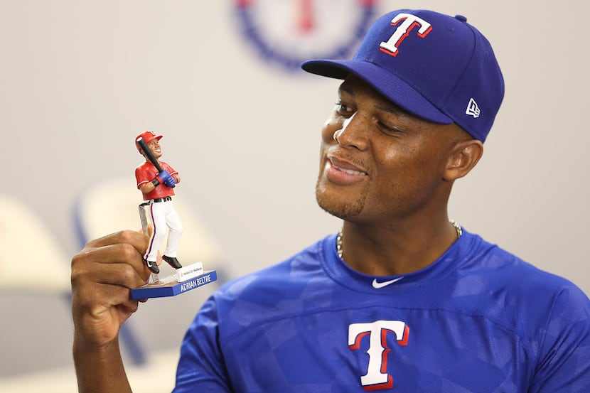 Adrian Beltre playing with his "Dancing Legs" bobblehead likeness.