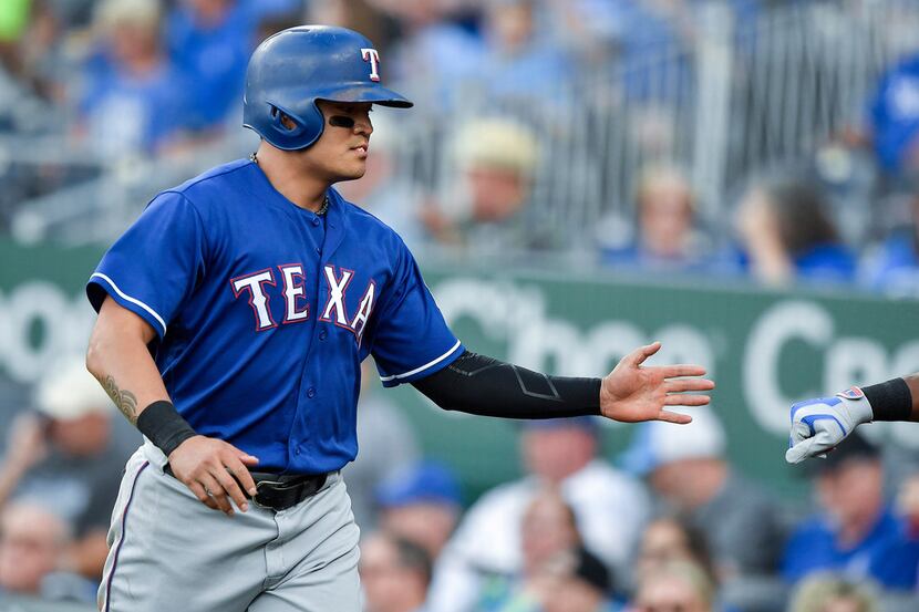 Texas Rangers' Shin-Soo Choo is greeted after scoring on a sacrifice fly by Nomar Mazara in...