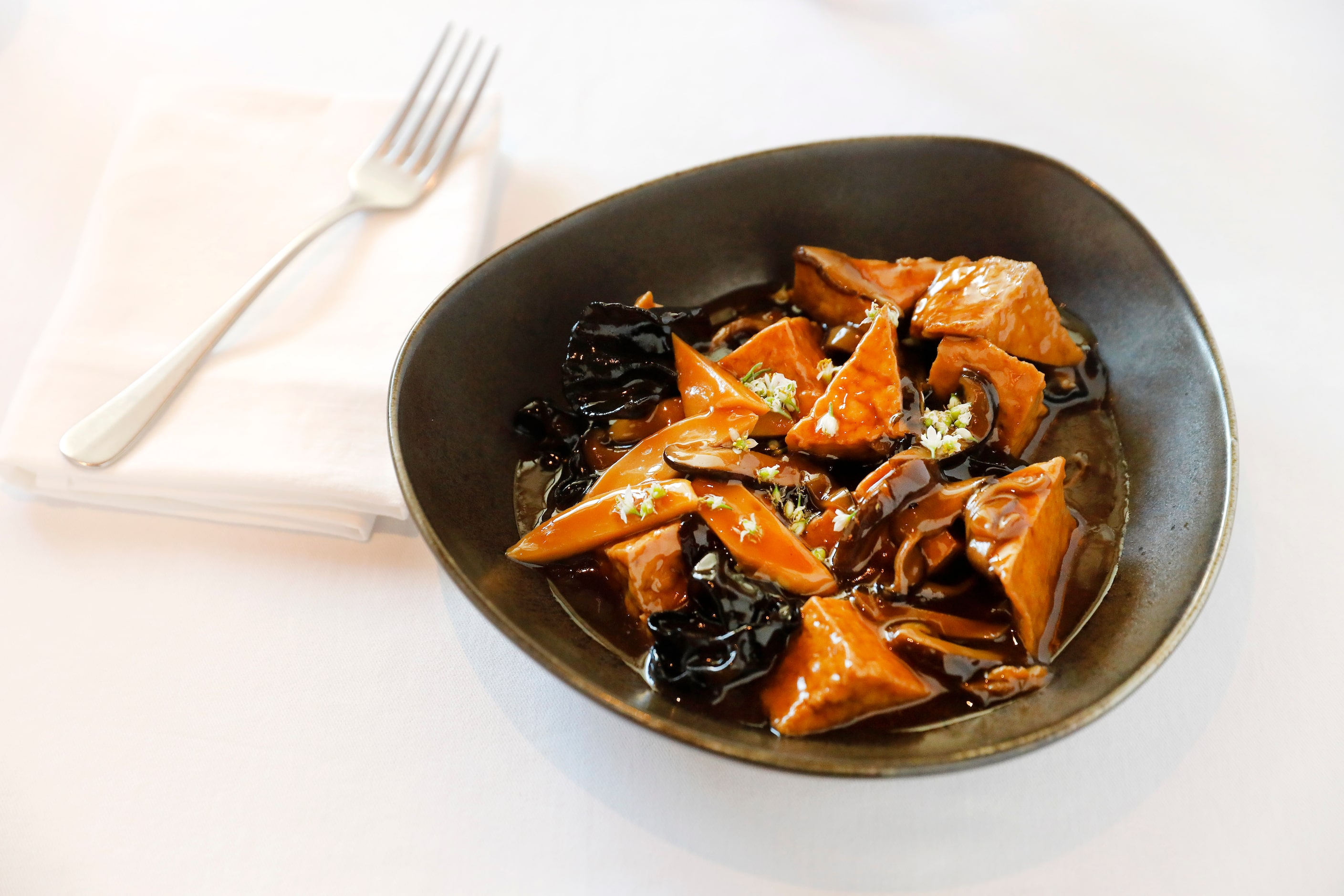 Braised tofu is prepared with black fungus, bamboo shoots, shiitake mushroom at Le PasSage,...