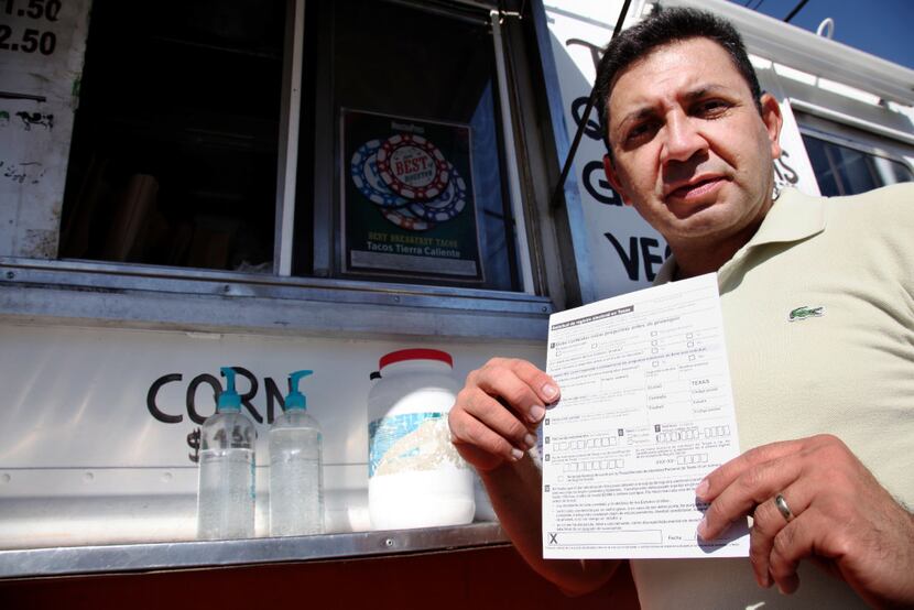 Carlos Zamora shows a voter registration card from a pile placed on the counter of the...