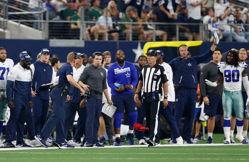 Dallas Cowboys head coach Jason Garrett speaks to side judge Scott Edwards (3) as he throws...