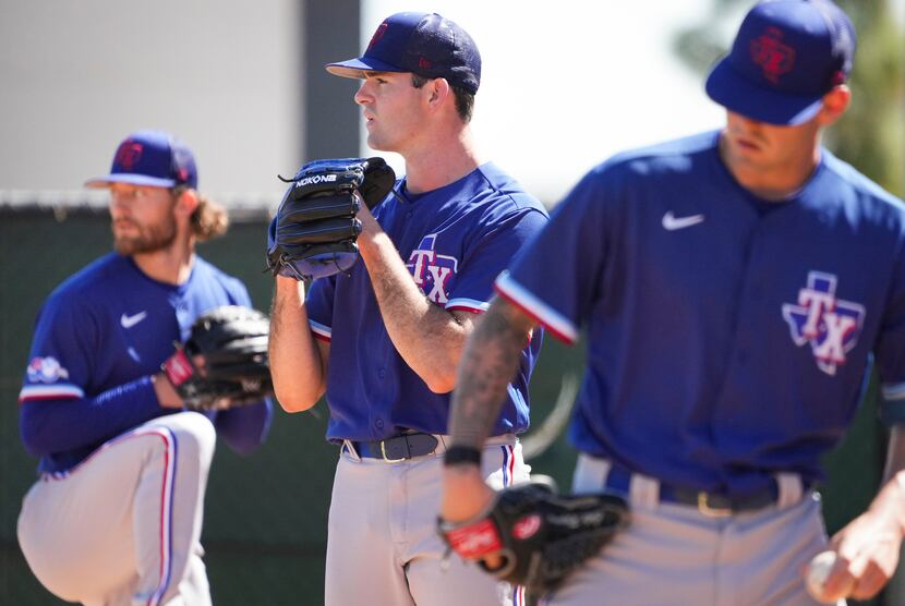 Texas Rangers pitchers Cody Bradford (center), Jake Latz (left) and Cole Ragans (right) work...