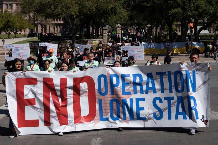 Protesters march from the Texas State Capitol to Republic Square park in downtown Austin to...