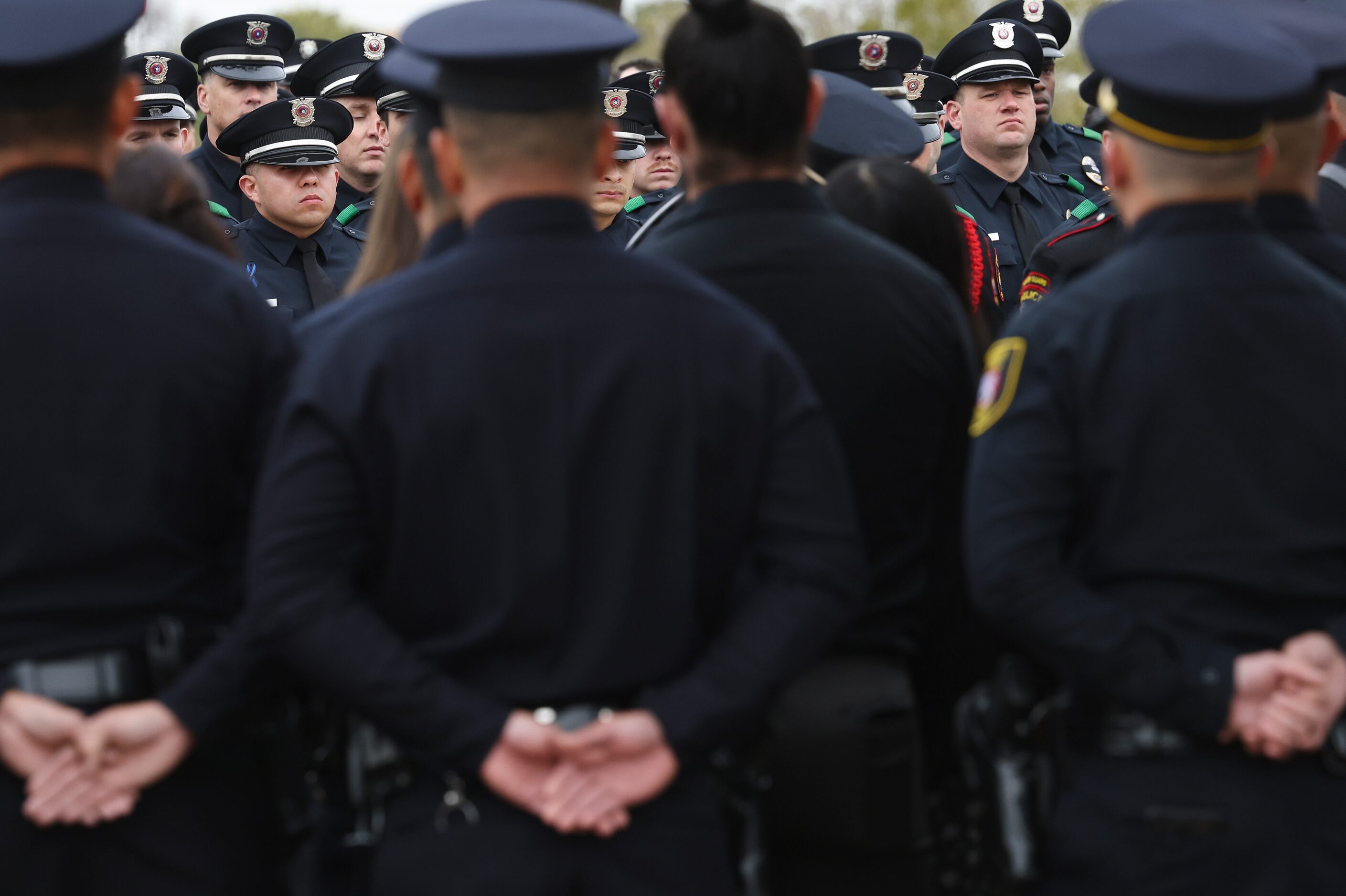 Police officers stand at attention around the casket of Grand Prairie police officer Brandon...