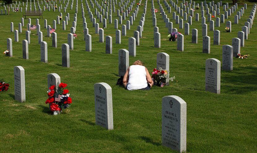  Mary Goodgion, 63, of Irving, Texas bows her head at her husband's grave at the Dallas-Fort...