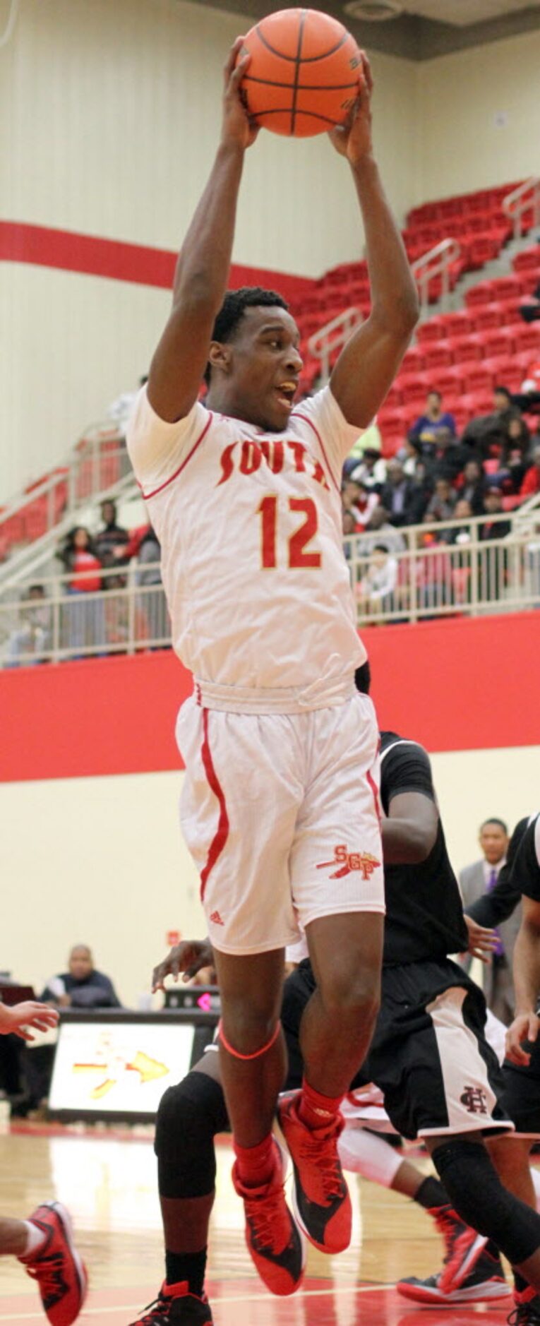 South Grand Prairie forward Cameron McGriff (12) goes high to pull down a rebound off the...