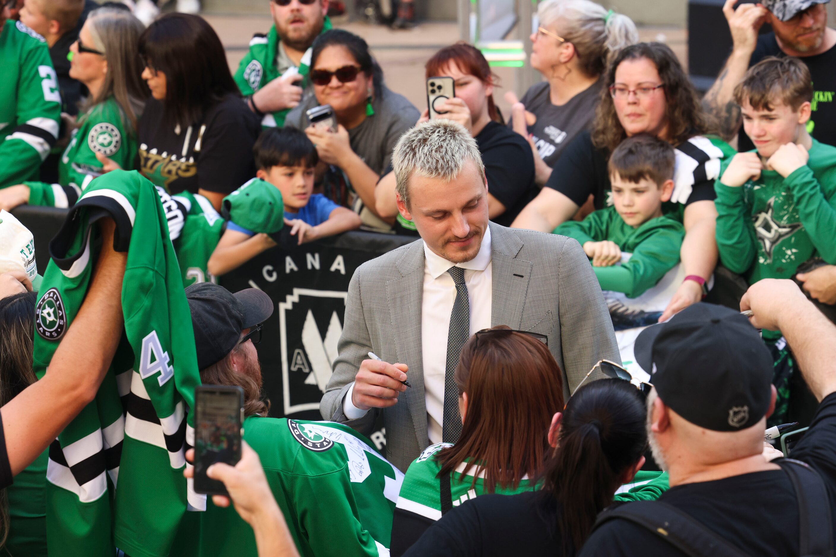 Dallas Stars center Roope Hintz gives autographs to fans as he makes his way during the...