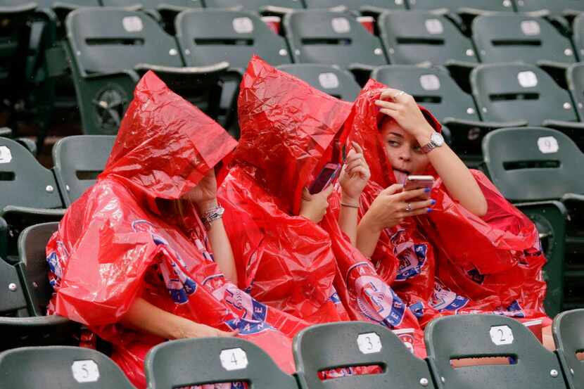Fans sit in the stands during a rain delay before a baseball game between the Oakland...