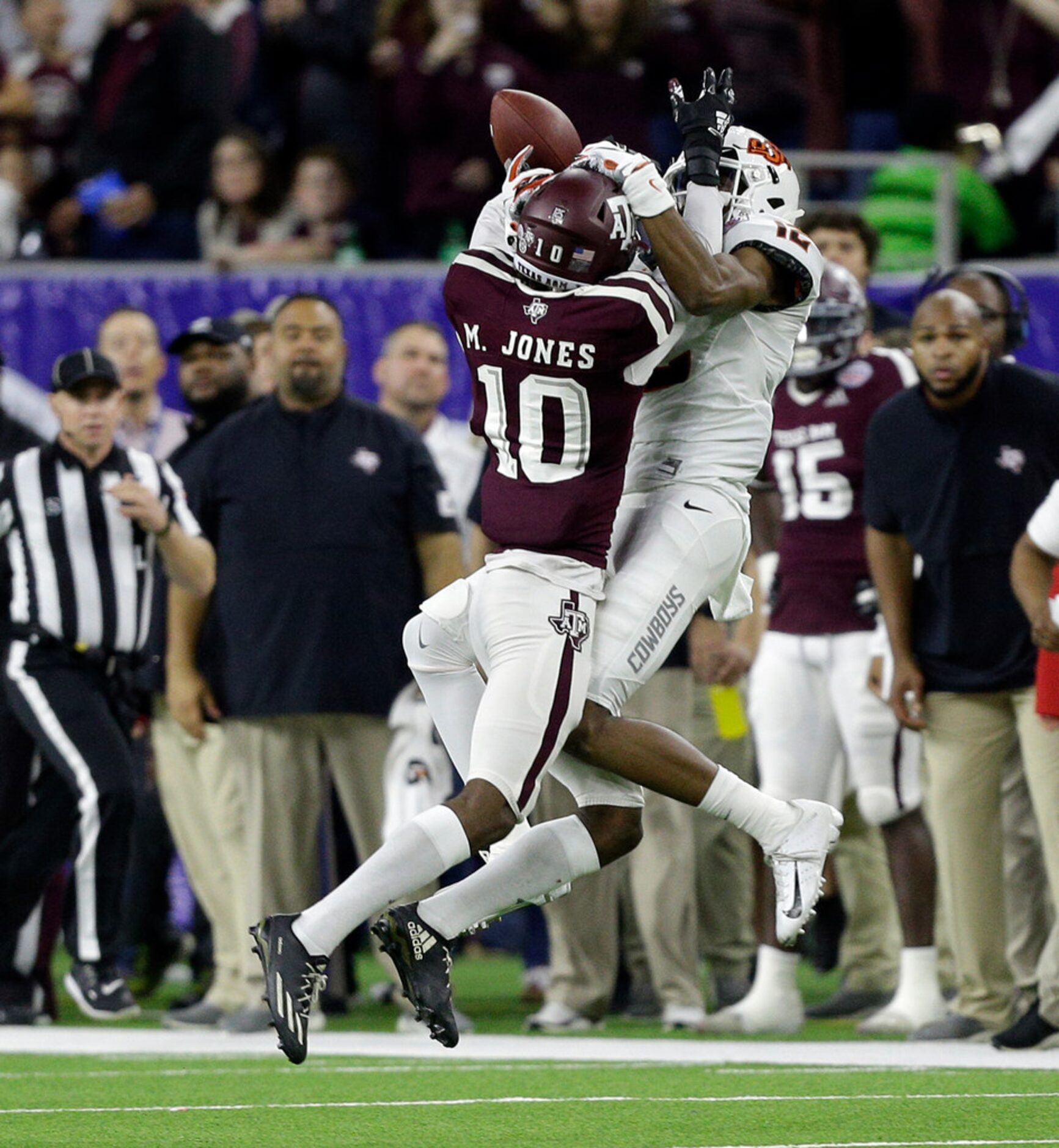 HOUSTON, TEXAS - DECEMBER 27: Myles Jones #10 of the Texas A&M Aggies breaks up a pass...