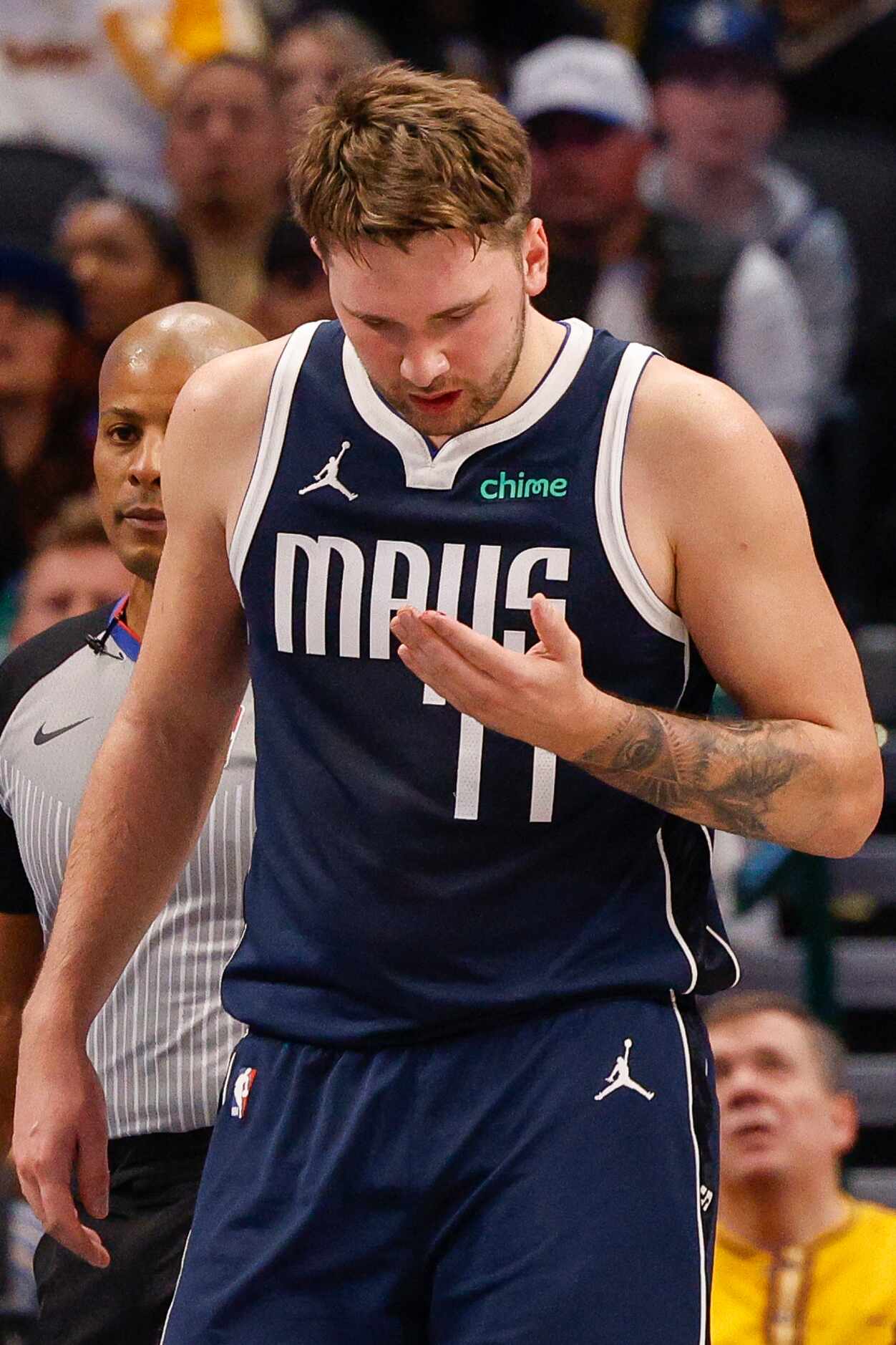 Dallas Mavericks guard Luka Doncic (77) wipes blood from his hand after a collision during...