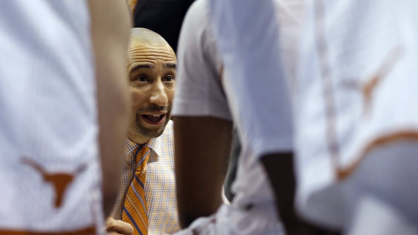 Texas Longhorns head coach Shaka Smart talks to his players during a timeout in a game...