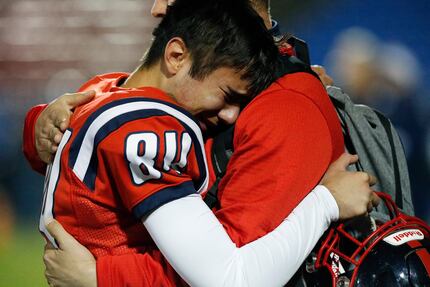 Centennial High School kicker Caleb Leal (84) is comforted by a coach after Centennial High...