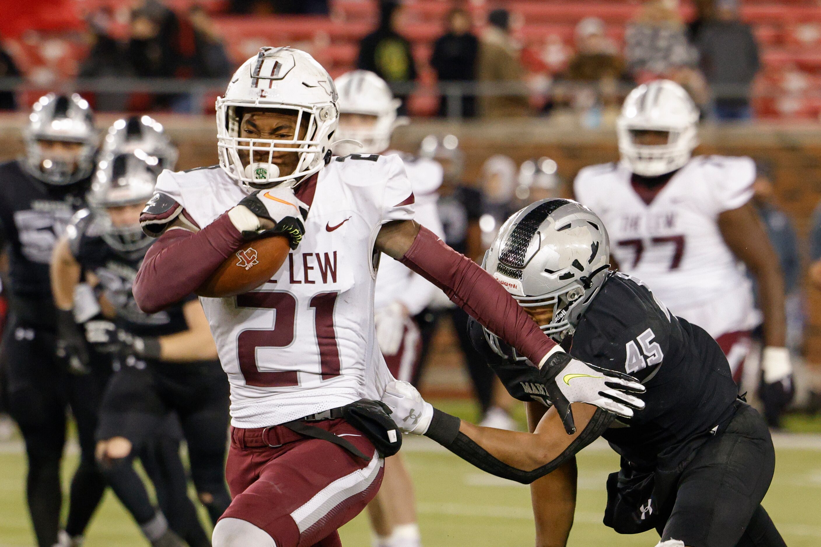 Lewisville running back Viron Ellison (21) runs through a tackle from Arlington Martin...