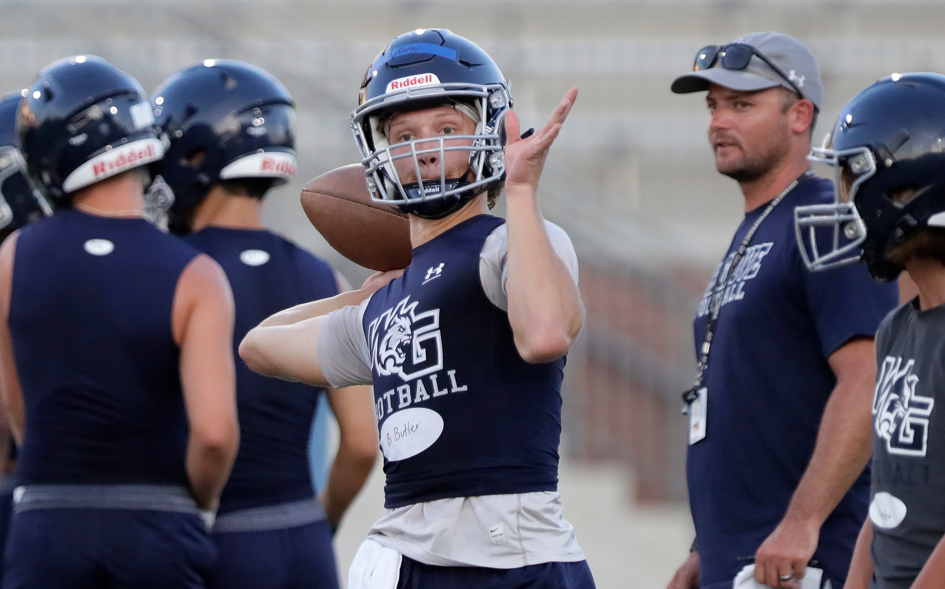 Quarterback Braden Butler throws a pass during a drill as Walnut Grove High School held...