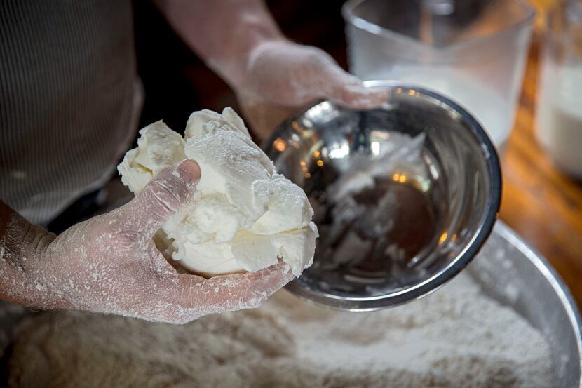 Chef Tim Byres adds lard to mixed, dry ingredients as he prepares buttermilk biscuits at...