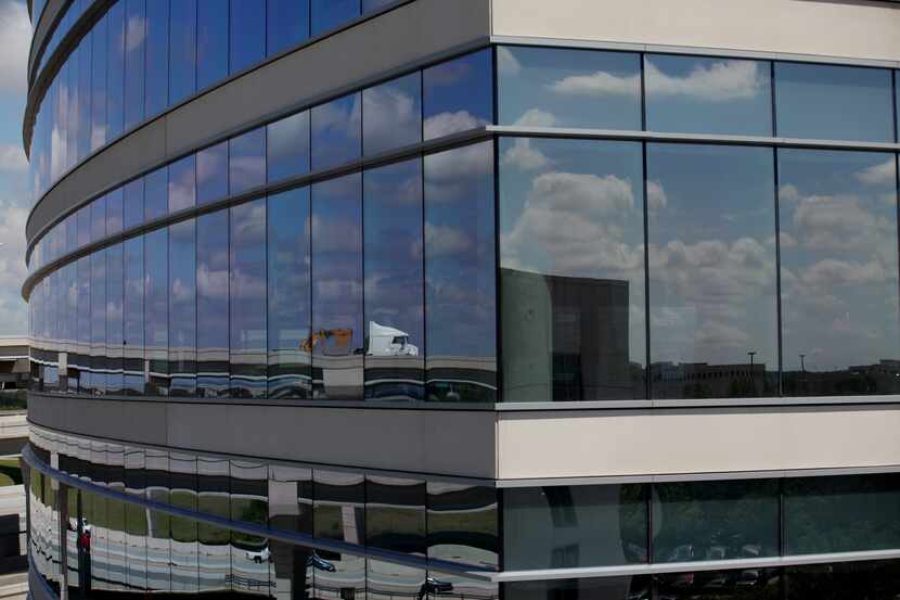 The entrance ramp to the Sam Rayburn Tollway is reflected in the Granite Park IV office...