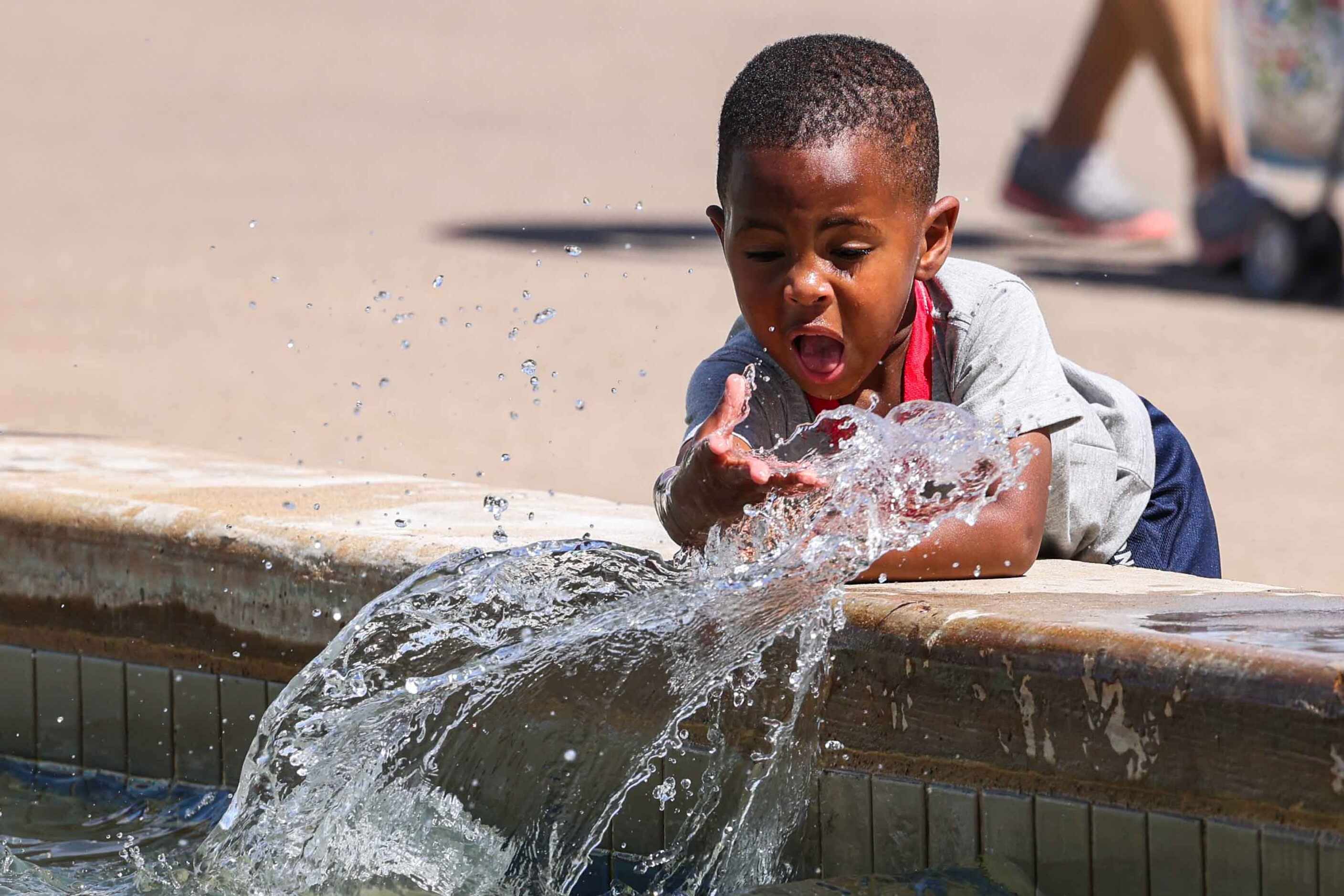 Jayden Williams, 2, plays with water at the Esplanade at the State Fair of Texas during its...