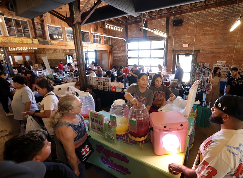 Vicki Medrano, left, and Sophie Ochoa with Aguas Chicas DFW make drinks during a community...