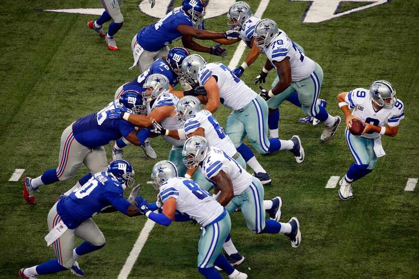 The Dallas Cowboys offensive line blocks the New York Giants for quarterback Tony Romo (9)...