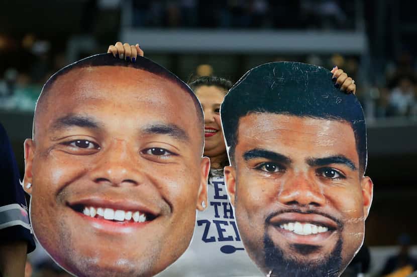 FILE - In this Jan. 15, 2017, file photo, a Dallas Cowboys fans holds face posters of Dallas...