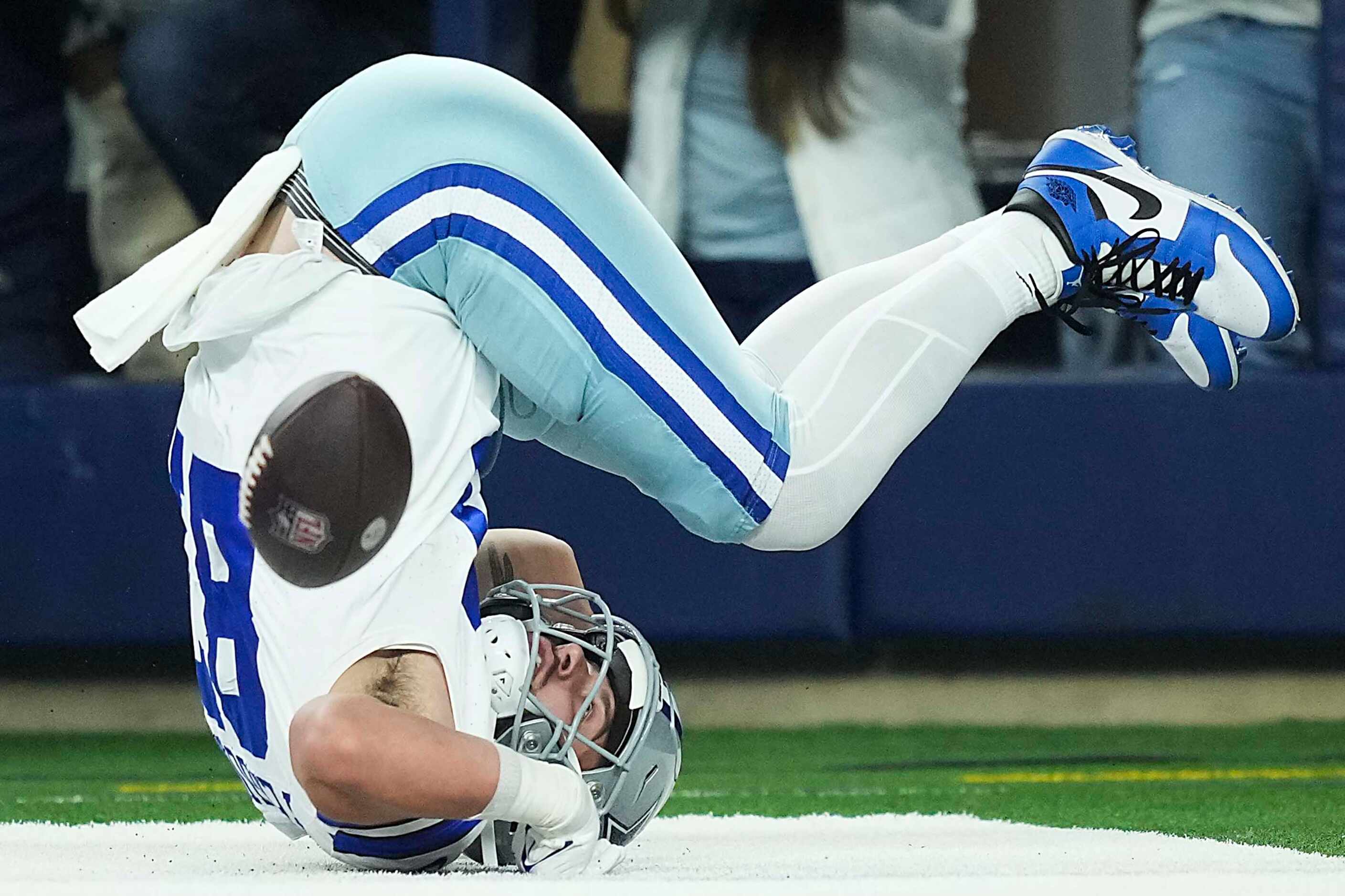 Dallas Cowboys tight end Jake Ferguson (87) tumbles out of the end zone after having a pass...