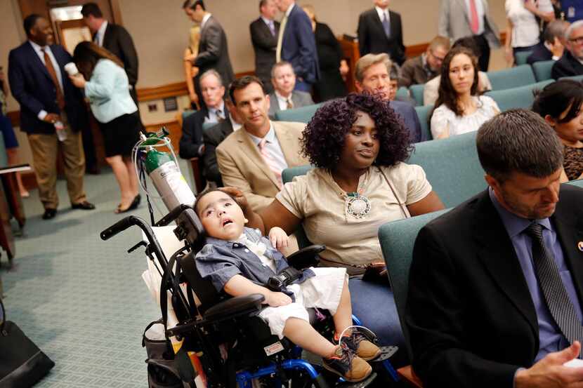 Linda Badawo of Mesquite waited with her 3-year-old son, D'ashon Morris, for testimony to...