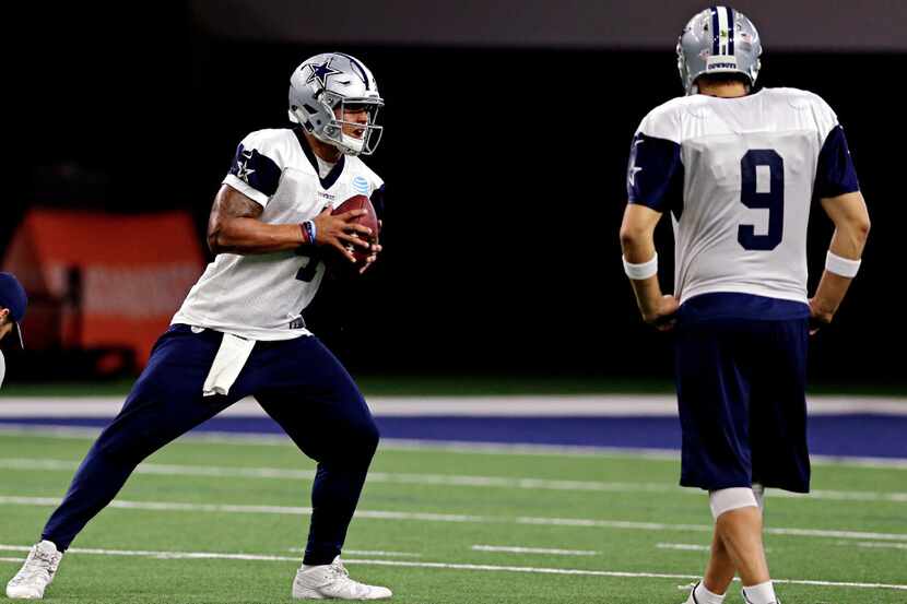 Dallas Cowboys quarterback Tony Romo (9) looks on as quarterback Dak Prescott runs a drill...