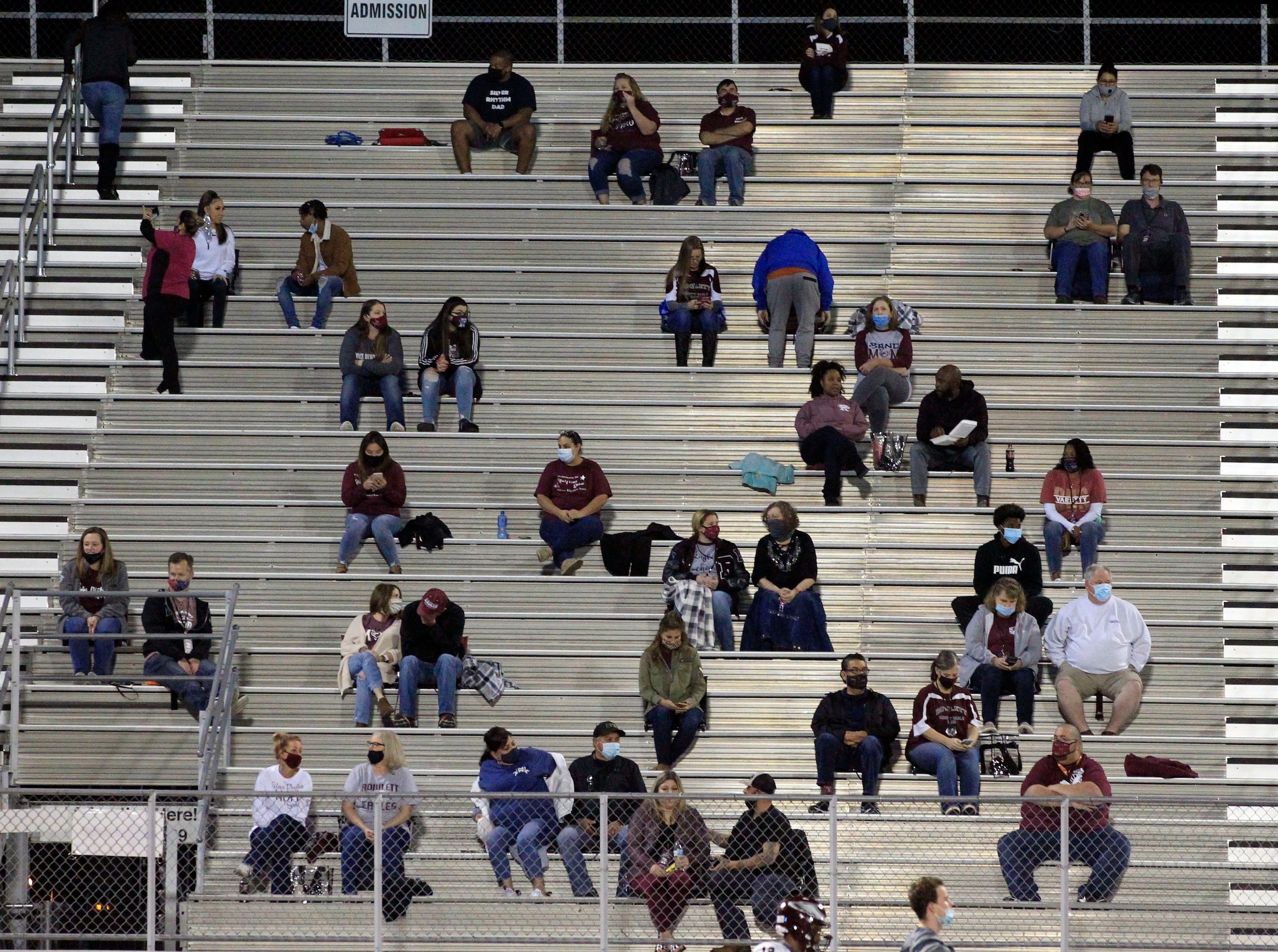 Rowlett fans carefully social distance from each other in the stands during the first half...