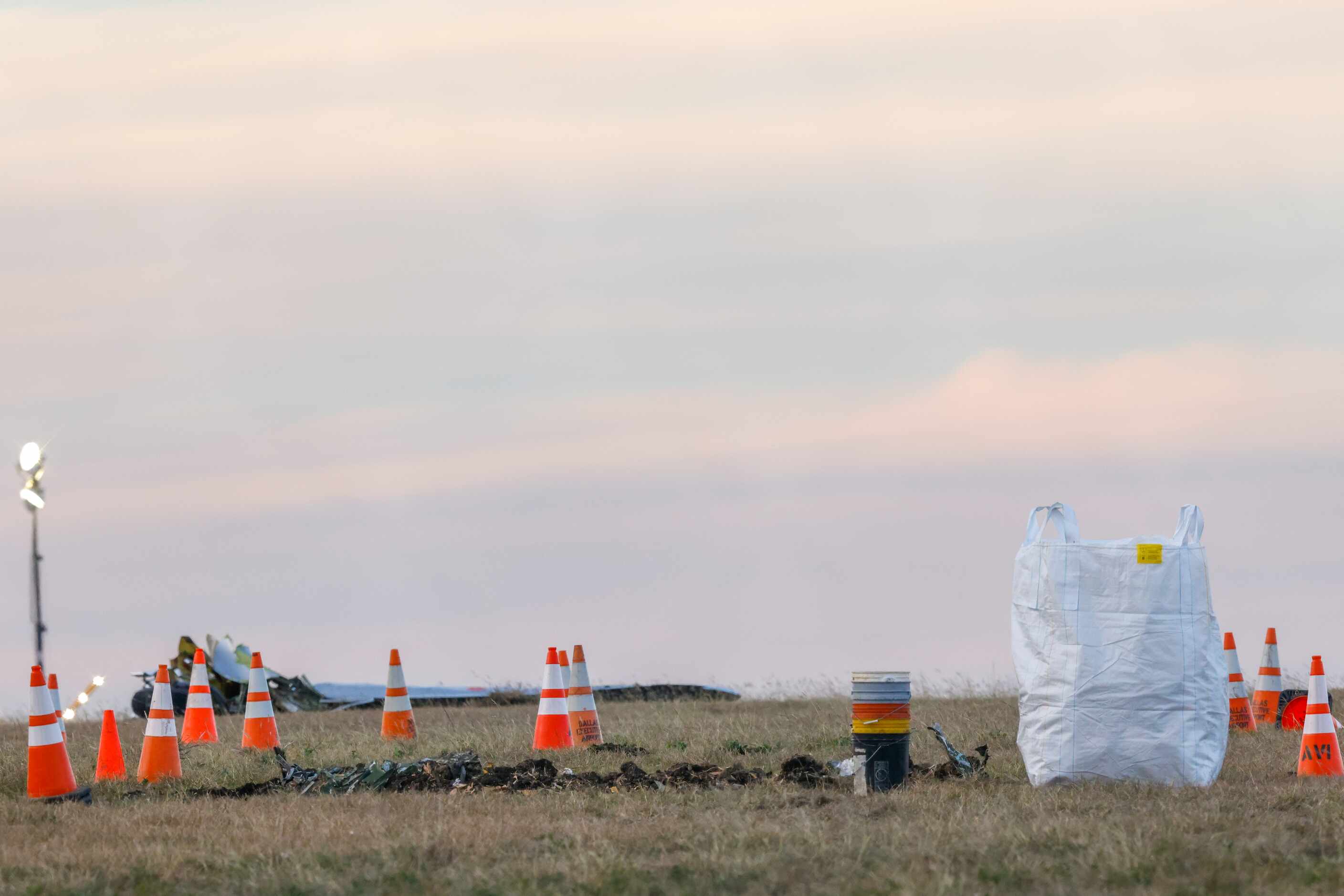 Cones, dirt and smaller debris remain after the damaged plane at the Dallas Executive...