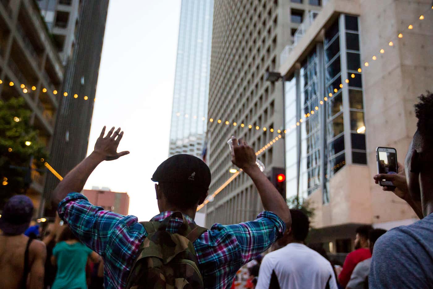 Demonstrators raise their hands during a Black Lives Matter march down Main Street in...