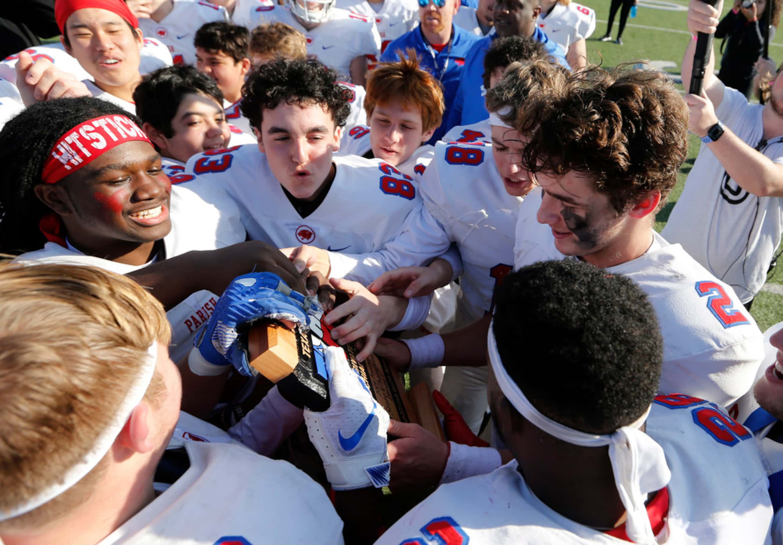 Parish Episcopal's Preston Stone (2) and teammates touch the trophy after receiving it...