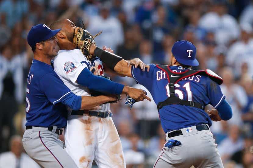 Texas Rangers starting pitcher Cole Hamels, left, restrains Los Angeles Dodgers' Matt Kemp...
