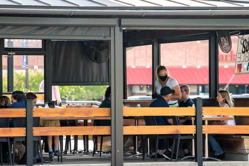 Patrons dine on the outdoor patio at Whiskey Cake Kitchen & Bar on Friday, May 1, 2020 in...