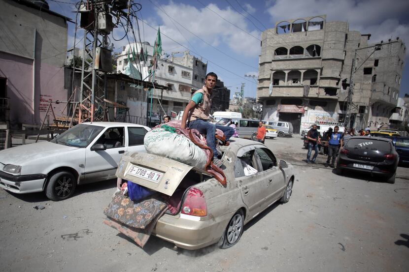 Palestinians salvage what little of their belongings they could from their homes during a...