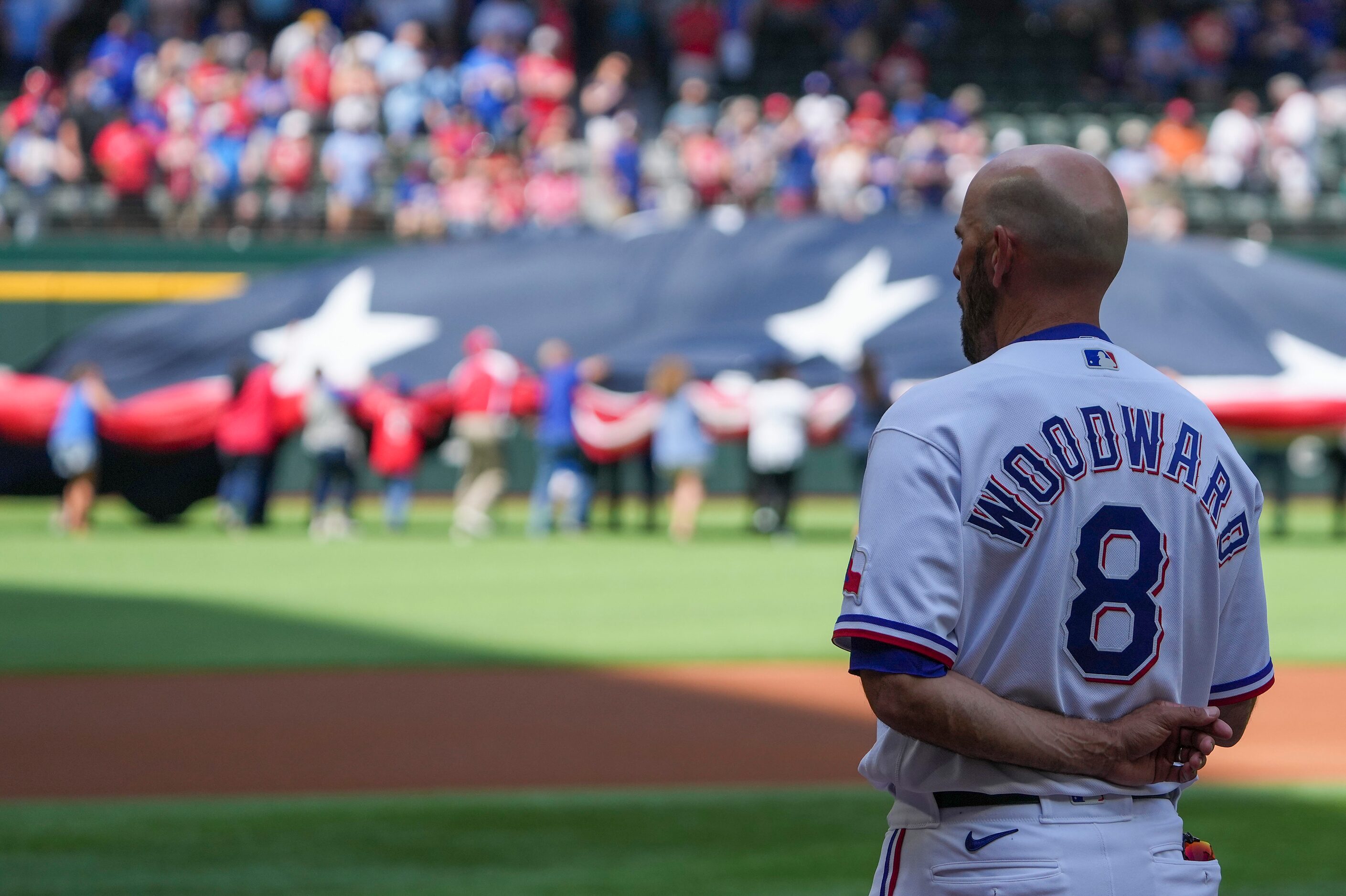 Texas Rangers manager Chris Woodward stands for the national anthem before the Rangers home...