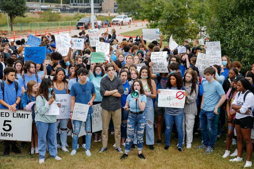 Guyer High School senior Chaney Tipton, 17 (center), speaks into a megaphone demanding...