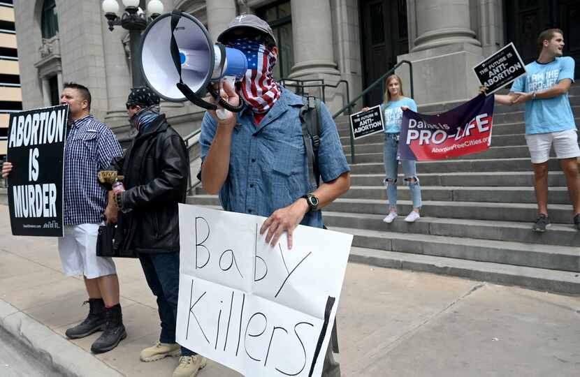 Daniel Lee, wielding a bullhorn in front of the Dallas Municipal Building, was among...