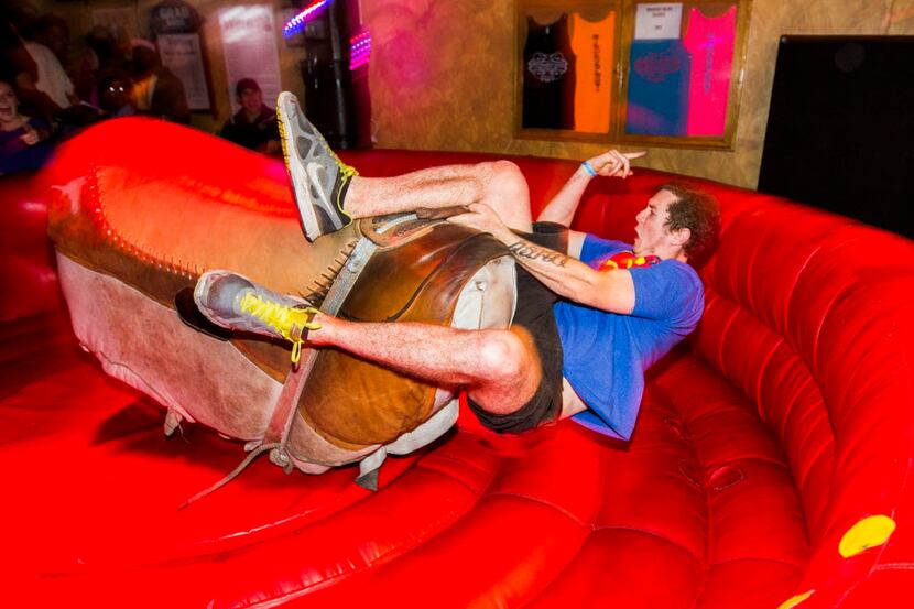 Cory Laubscher of Georgetown, Texas, falls off a mechanical bull at The Trophy Club on Sixth...