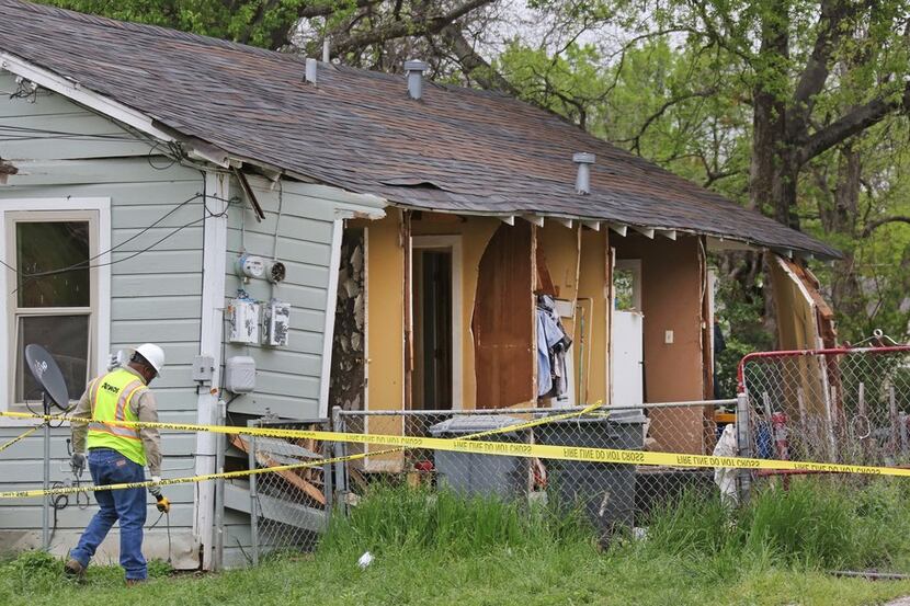 An Atmos Energy worker investigates a house explosion at 3700 Spring Avenue in Dallas, near...