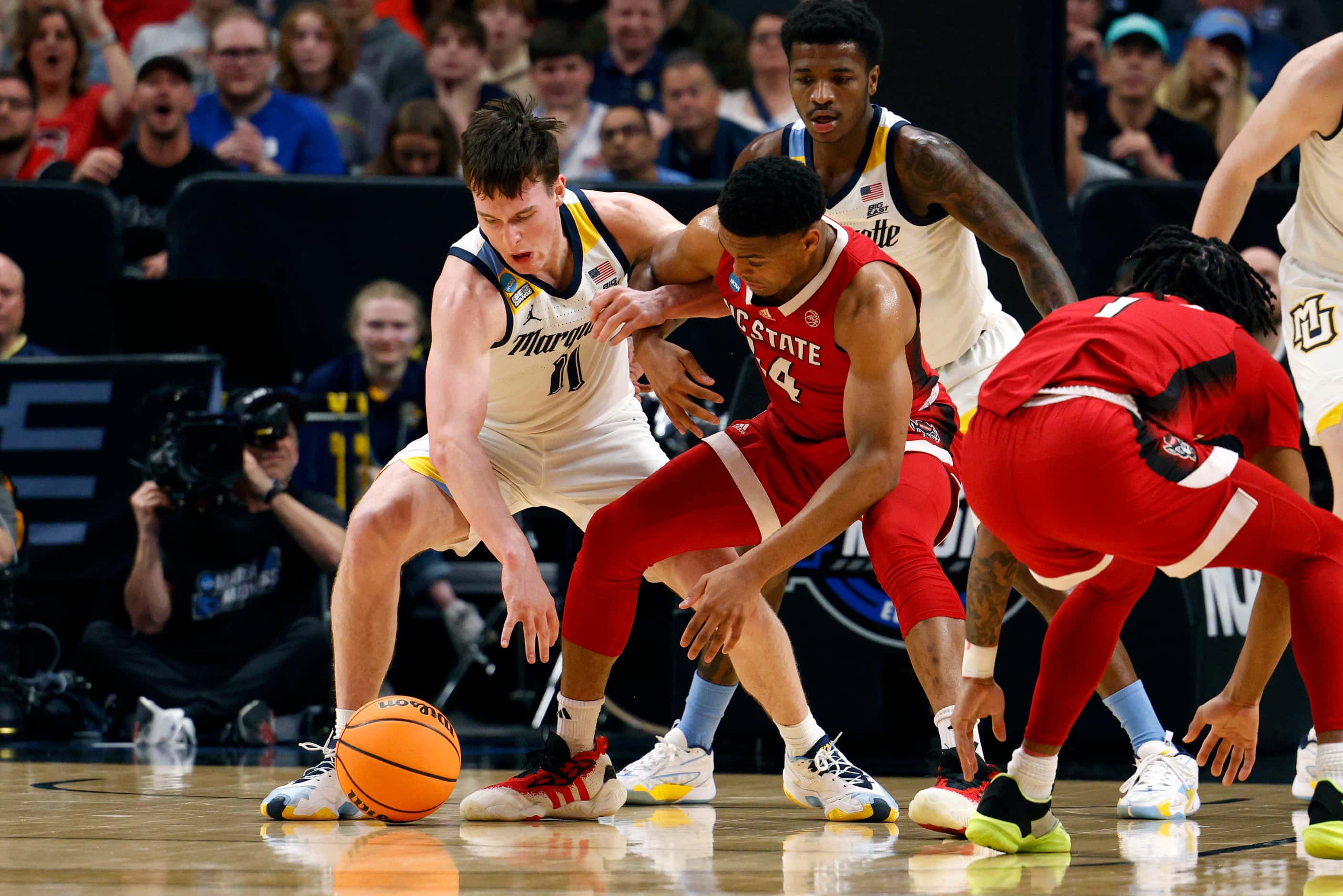 Marquette guard Tyler Kolek (11) and North Carolina State guard Casey Morsell (14) during...