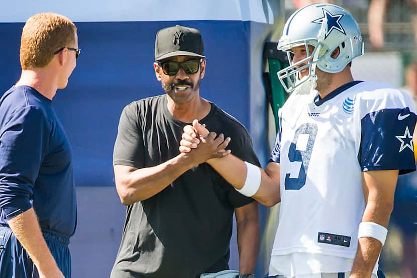 Actor Denzel Washington chats with quarterback Tony Romo and head coach Jason Garrett before...