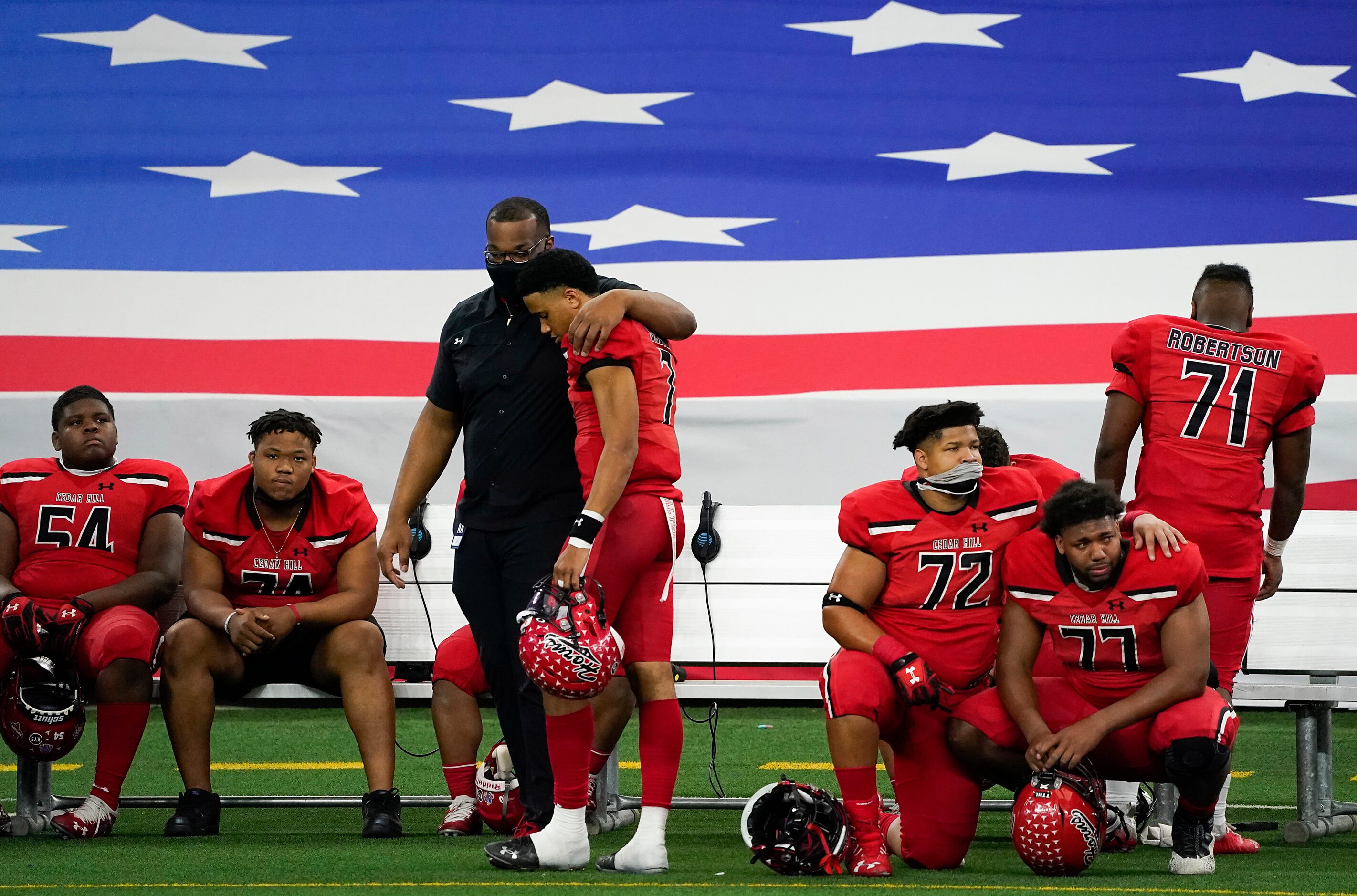 Cedar Hill quarterback Kaidon Salter (7) is consoled by a coach as teammates Matthew Worth...