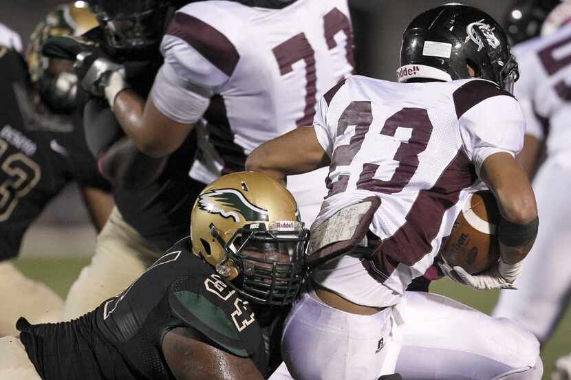 Mansfield Timberview Wolves running back Mason Miller (23) is tackled for a lose by DeSoto...