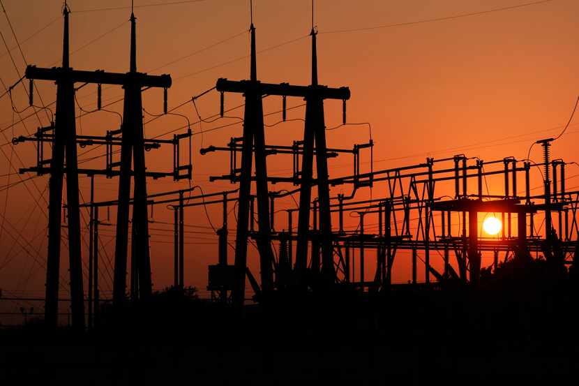 La puesta de sol a través de la subestación eléctrica de Brazos Electric Power Cooperative,...