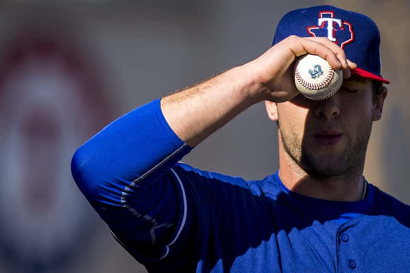 Texas Rangers pitcher Scott Williams adjusts his cap before pitching in the bullpen during a...