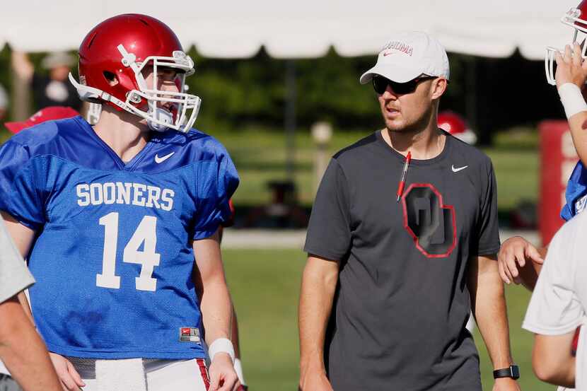 Oklahoma head coach Lincoln Riley, right, talks with quarterback Reece Clark (14) during an...