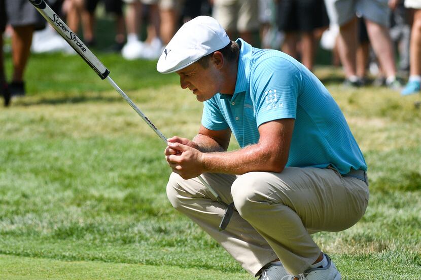 Bryson DeChambeau reacts after missing his putt on the ninth green during the first round of...