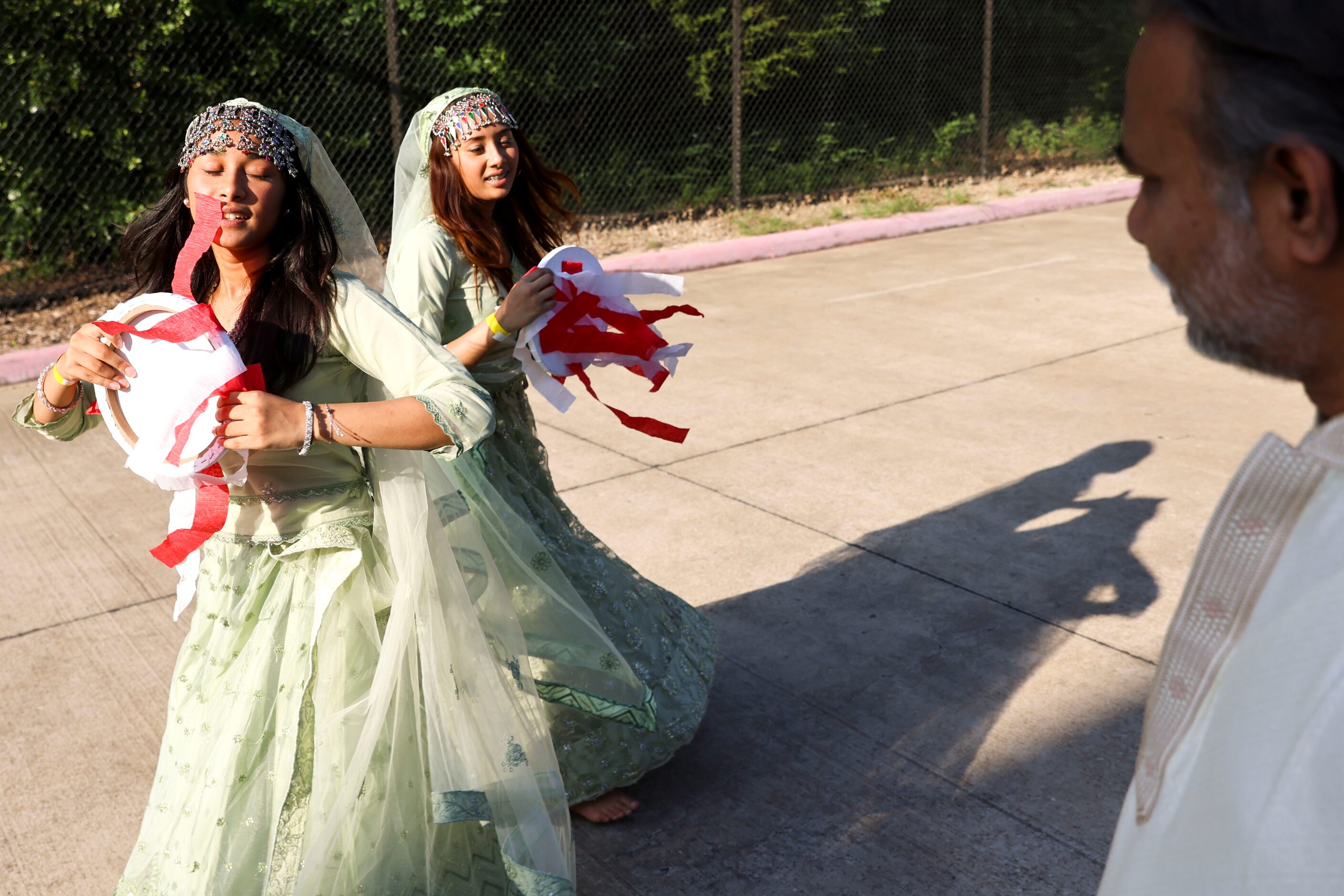 Nova (left) and her sister Nora, rehearse their dance performance in a parking lot as their...