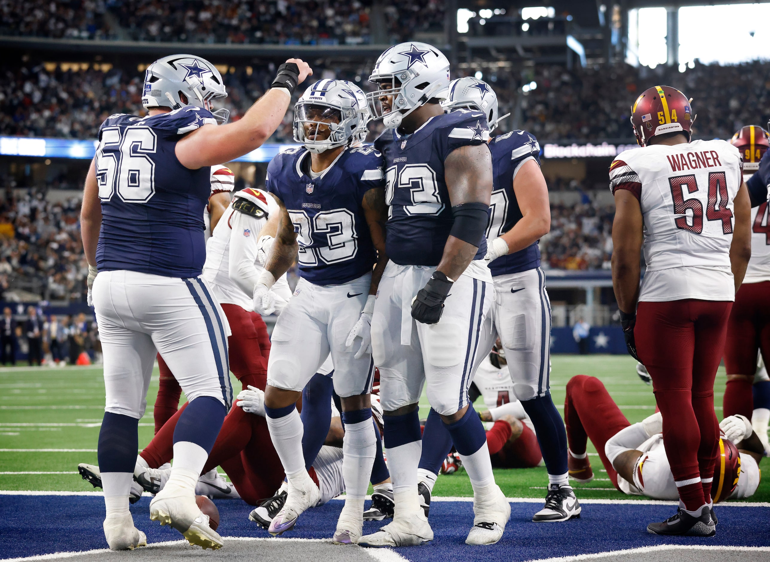 Dallas Cowboys running back Rico Dowdle (23) is congratulated by teammate Cooper Beebe (56)...