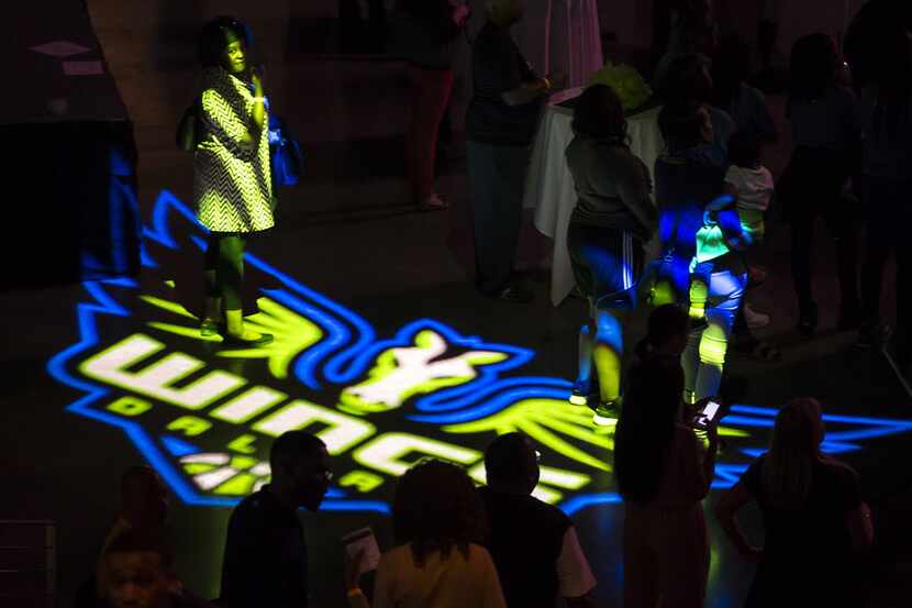 Fans walk across the floor of the arena during the Dallas Wings WNBA draft night party at...